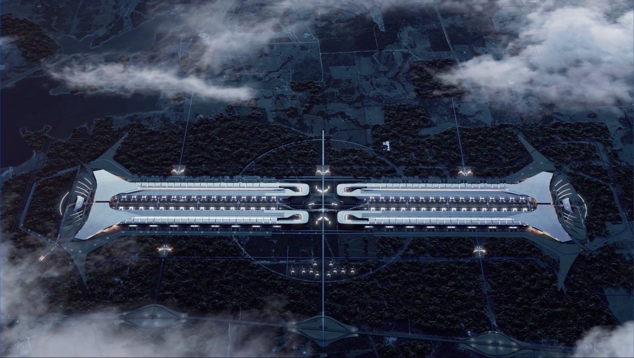 Dusk aerial rendering of the planned Terafab complex: two long, brightly lit parallel building rows joined by flared structures at each end, set among forest and fields inside a circular site boundary